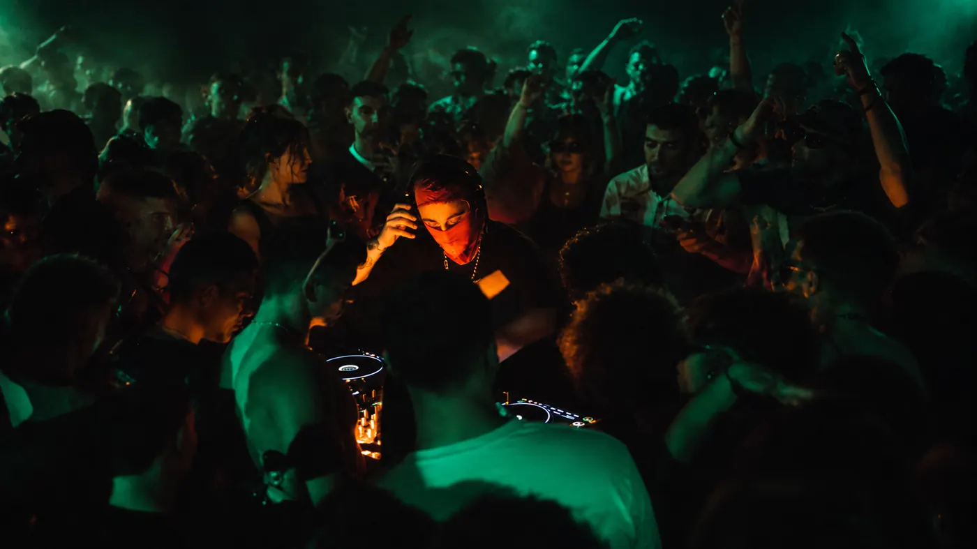 ANTIK pinchando rodeado de público en una sala